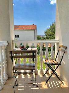 eine Veranda mit einem Tisch und 2 Stühlen auf einem Balkon in der Unterkunft Apartment Pepa Starigrad Paklenica in Starigrad-Paklenica