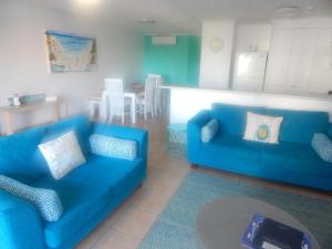a living room filled with furniture and a blue couch at Tranquil Shores in Caloundra