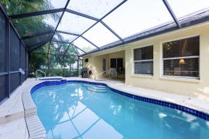 an indoor swimming pool with a glass roof at Serene & Attractive Heated Pool Spa Home in Estero