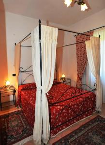 a bedroom with a red bed with a canopy at Agriturismo Santa Veronica in Acquapendente