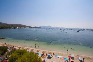 
people on the beach with umbrellas at Hoposa Bahia in Port de Pollensa
