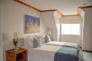 a bedroom with a large white bed with a window at Hotel Casa Marron in Villarrica