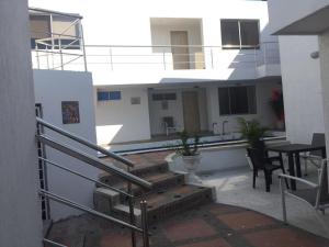 uma varanda de uma casa com escadas e uma mesa em Villa Mary Hostal em Barranquilla