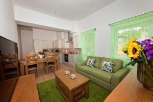 a living room with a green couch and a kitchen at Best Luxury Apart Hotel in Oxford- Beechwood House in Oxford