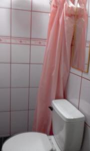 a bathroom with a toilet and a pink shower curtain at Casa Blanca Tu Casa in Santa Ana +63 photos