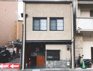 un edificio con una ventana y una motocicleta estacionada fuera en Kyoto Shijo Guest House Ayaomiya villa, en Kioto