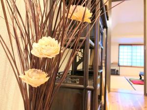 un jarrón con flores blancas en una habitación en Kyoto Shijo Guest House Ayaomiya villa, en Kioto