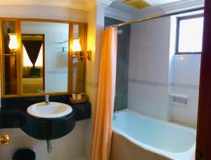 y baño con lavabo, bañera y ducha. en The Executive Hotel Lahad Datu, en Lahad Datu