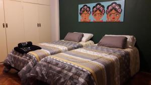 dwa łóżka siedzące obok siebie w pokoju w obiekcie Viva San Martín, Apartamento Luminoso w BuenosAires