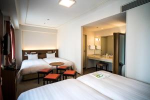 a hotel room with two beds and a sink at Hotel New Hankyu Osaka Annex in Osaka