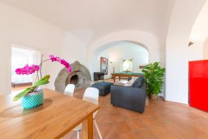 uma sala de estar com uma mesa e um sofá em Villa Regine Apartments em Ischia