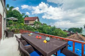 a table on the balcony with a view of the ocean at Villa Keluarga in Nusa Lembongan