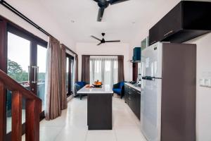 a kitchen with a refrigerator and a table in it at Villa Keluarga in Nusa Lembongan