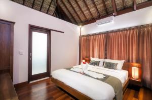 a bedroom with a large bed with a window at Villa Keluarga in Nusa Lembongan
