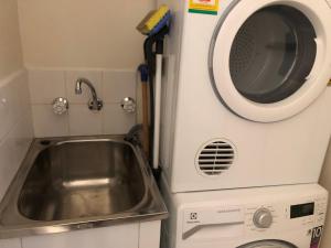 a kitchen with a sink and a washing machine at 1 Bedroom Unit in Heart of Elsternwick in Melbourne