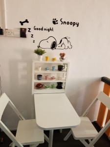 a table and a chair with a good night sticker on a wall at Home@KKB in Kuala Kubu Baharu