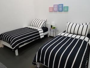 two beds in a room with black and white stripes at Home@KKB in Kuala Kubu Baharu