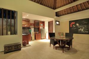 a kitchen and dining room with a table and chairs at Puri Mas Boutique Resort & Spa in Senggigi