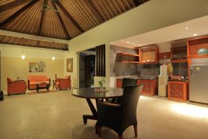 a kitchen and living room with a table and chairs at Puri Mas Boutique Resort & Spa in Senggigi