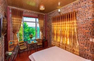 sypialnia z ceglaną ścianą, łóżkiem i stołem w obiekcie Bai Dinh Eco Homestay w mieście Ninh Binh