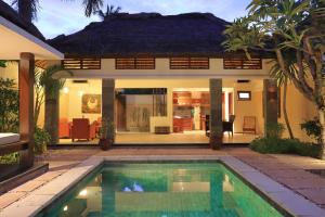 a house with a swimming pool in front of a house at Puri Mas Boutique Resort & Spa in Senggigi