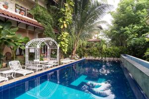 a resort pool with chairs and a gazebo at Collection O near University of Sumatera Utara formerly Huber Apartment in Medan