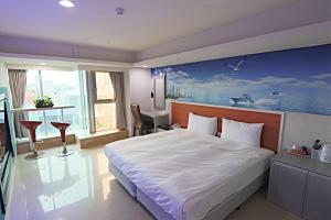 um quarto com uma cama grande e uma pintura na parede em E Lim Hotel em Zhongli