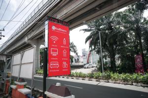 RedDoorz near Palembang Square Mall 2 في باليمبانغ: علامة حمراء على جانب المبنى