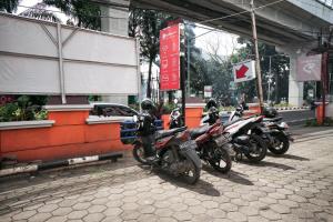 RedDoorz near Palembang Square Mall 2 في باليمبانغ: صف من الدراجات النارية متوقفة أمام مبنى