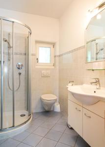 een badkamer met een douche, een toilet en een wastafel bij Gästehaus Seitzhof in Merano