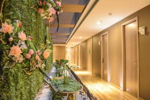 a corridor with plants and flowers on a wall at Hotel Catedral Plaza in Santa Marta