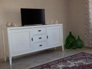 a white dresser with a tv on top of it at Casavacanze PugliaMia in Grottaglie