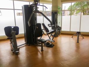 a gym with treadmills and chairs in a room at Comfy Studio Apartment No Kitchen Mustika Golf Residence By Travelio in Pegadungan