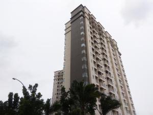 a tall building with palm trees in front of it at Comfy Studio Apartment No Kitchen Mustika Golf Residence By Travelio in Pegadungan