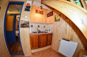 una cocina en una casa pequeña con un arco en Malom Apartman 2, en Derekegyház