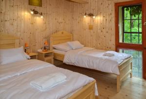 2 camas en una habitación con paredes de madera en Malom Apartman 2, en Derekegyház