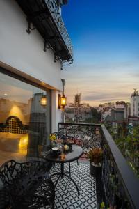 Hanoi Esplendor Hotel and Spa في هانوي: بلكونه مع طاوله وكراسي واطلاله