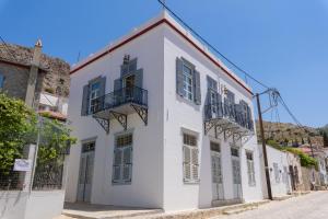 ein weißes Gebäude mit Balkon auf einer Straße in der Unterkunft Hydra's Pearl - Gold Pearl in Hydra