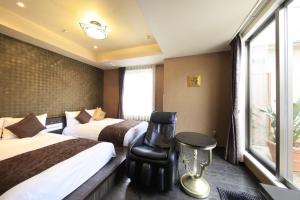 東京にあるホテル ココ・グラン北千住のベッド2台と窓が備わるホテルルームです。