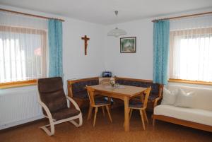 sala de estar con mesa, sillas y sofá en Apartment Maierhof, en Flirsch