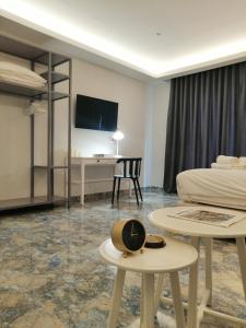 um quarto de hotel com uma cama e uma mesa com um chapéu em 24K Athena Suites em Atenas