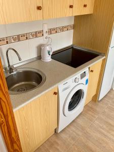 een keuken met een wastafel en een wasmachine bij Apartment in Torrevieja