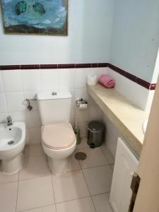 a white bathroom with a toilet and a sink at Aguaviva in Callao Salvaje