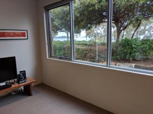 アルバニーにあるHanover Bay Apartmentsの窓、テーブル、テレビが備わる客室です。