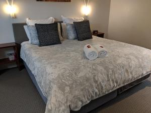 a bedroom with a bed with two towels on it at Hanover Bay Apartments in Albany
