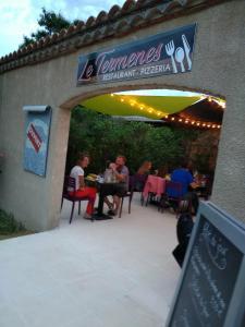 a group of people sitting at tables at a restaurant at Le Termenès in Félines-Termenès