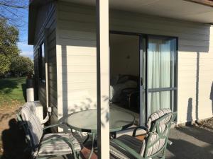 a patio with a table and chairs on a house at Bluebell Lodge and Cottage in Havelock North