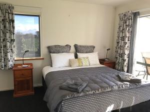 a bedroom with a large bed with a window at Bluebell Lodge and Cottage in Havelock North +77 photos