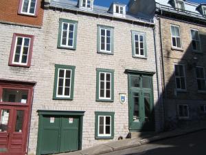 un gran edificio de ladrillo con puertas y ventanas verdes en Le Coureur Des Bois, en Quebec