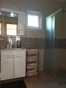 a bathroom with a sink and a shower and a sink at Apartments Laura in Rakovica